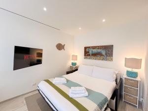 a white bedroom with a bed and a tv at Casa Elisabeth in Portovenere