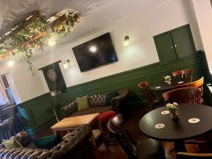a restaurant with tables and chairs and a tv at The Old Cross Inn in Blairgowrie
