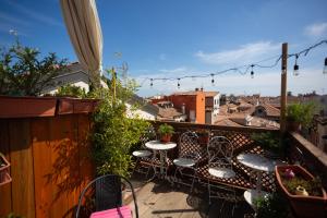 a balcony with tables and chairs and a view of a city at B&B Basta Bussare in Chioggia