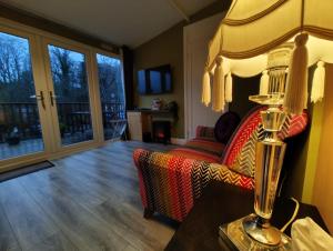 a living room with a couch and a table with a lamp at Crofters Cabin in Caernarfon