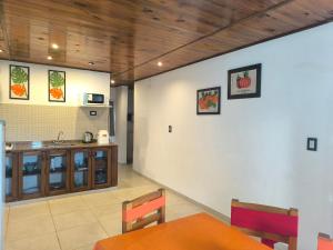 a dining room with a table and a kitchen at Cabañas La Soñada in Chajarí