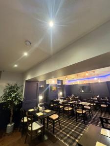 a restaurant with tables and chairs in a room at The Old Cross Inn in Blairgowrie