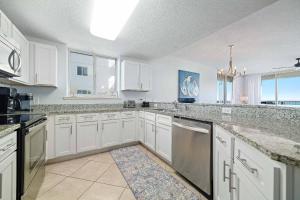 a large kitchen with white cabinets and appliances at Beach Club D-801 in Gulf Highlands