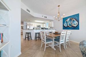 a dining room and kitchen with a table and chairs at Beach Club D-801 in Gulf Highlands