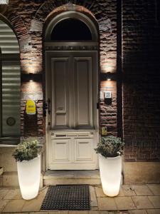 une porte avec deux plantes en pot devant elle dans l'établissement B&B Leopold Appartementen & studio's, à Saint-Trond