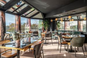 a restaurant with tables and chairs and windows at Hyatt Centric Reims in Reims