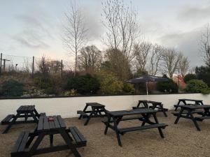 a group of picnic tables in front of a wall at The Old Cross Inn in Blairgowrie