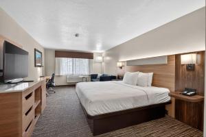 a hotel room with a bed and a flat screen tv at Best Western Timpanogos Inn in Lehi