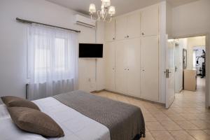 a bedroom with a bed and a television in it at Anchor House Santorini in Fira