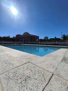 a large swimming pool with a building in the background at Cabañas La Soñada in Chajarí