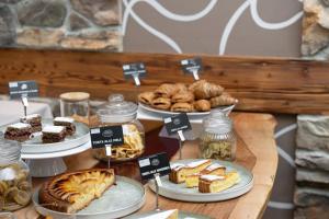 a display of desserts and pastries on plates on a table at Hotel La Bussola in Andalo