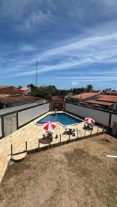 a swimming pool with two umbrellas on top of a building at Espaço Mãe Cecília in Paripueira