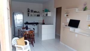 a small kitchen with a table and a refrigerator at Espaço Mãe Cecília in Paripueira