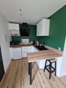 a kitchen with white cabinets and a wooden counter top at Port de la paix in Biganos +9 photos