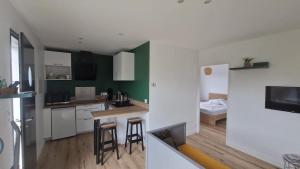 a kitchen with green walls and a kitchen with stools at Port de la paix in Biganos