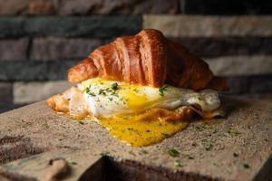 an egg sandwich with a croissant on a table at PF Hotel in San Felipe de Puerto Plata
