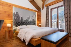a bedroom with a bed and a large window at Hotel La Bussola in Andalo