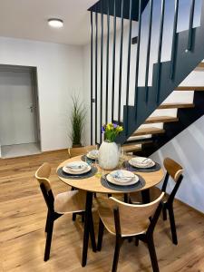 a dining room table with chairs and a staircase at Core Apartments Jihlava in Jihlava