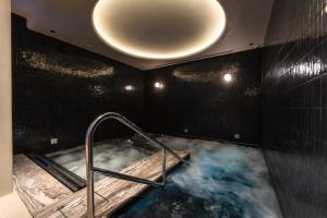 a bathroom with a hot tub with a circular light at The Newman in London