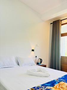 a bedroom with a white bed with a window at Ella Heaven View in Ella