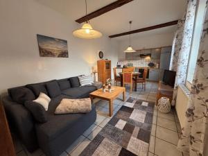 a living room with a couch and a table at FeWo 2 - Haus Lorenzen in Hörsten
