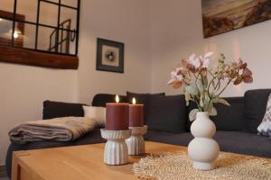 a living room with a table with candles and a couch at FeWo 2 - Haus Lorenzen in Hörsten
