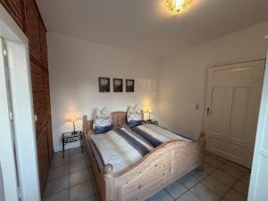a bedroom with a large wooden bed with two lamps at FeWo 2 - Haus Lorenzen in Hörsten +1 photo