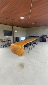 a large wooden table in a room with chairs at Rancho Helena in Maceió