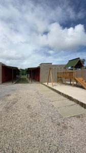 a group of buildings with a bench and a pavilion at Rancho Helena in Maceió