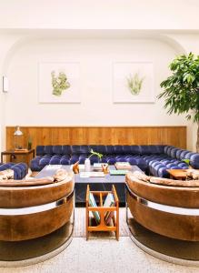 a room with a couch and a table and chairs at Tilden Hotel in San Francisco