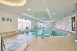 a large pool with a hot tub in a building at Nord-A Waterlane Island SPA in Gdańsk