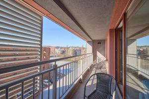 a balcony with a chair and a view of the city at Nord-A Waterlane Island SPA in Gdańsk