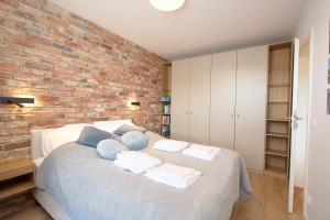 a bedroom with a brick wall and a bed at Nord-A Waterlane Island SPA in Gdańsk +4 photos