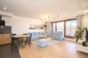 a living room with a couch and a table at Nord-A Waterlane Island SPA in Gdańsk