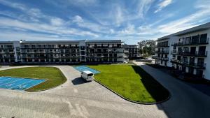 an aerial view of an apartment complex with a parking lot at Sand & Wave - Luxury Marina View Apartment with Spa, Pool & Free Parking in Dziwnów