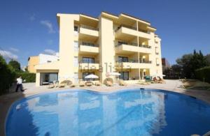 a large building with a swimming pool in front of it at MallorcaRooms Cala Millor in Cala Millor