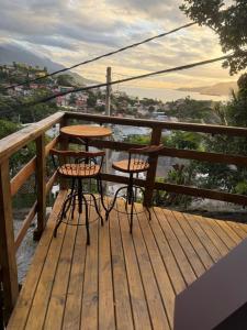 a table and two chairs on a wooden deck at A Cabana Caiçara in Ilhabela