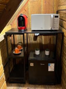 a microwave sitting on top of a table at A Cabana Caiçara in Ilhabela +11 photos