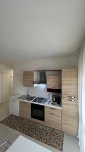 a kitchen with wooden cabinets and a stove top oven at Luminoso Appartamento al mare in Martinsicuro