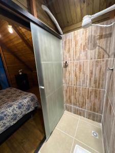 a shower with a glass door in a room at A Cabana Caiçara in Ilhabela