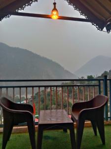 two chairs and a table on a balcony with a view at Mountain View Cottage Shivpuri Rishikesh in Rishīkesh