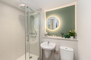 a bathroom with a toilet and a sink and a mirror at Sella Park Country House Hotel in Seascale +48 photos