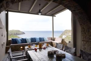 a dining room with a table and a view of the ocean at GL Villa in Agios Romanos