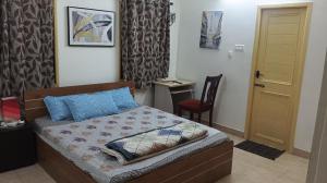 a bedroom with a bed and a chair and a door at Comfort Zone in Chennai +26 photos