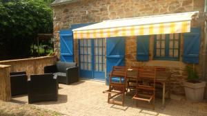a patio with a table and chairs under a canopy at KERMARIUs in Plougastel-Daoulas