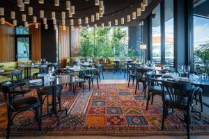 a restaurant with tables and chairs on a rug at Memmo Príncipe Real, a Member of Design Hotels in Lisbon