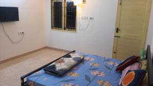 a bedroom with a bed with a blue comforter and a window at Comfort Zone in Chennai