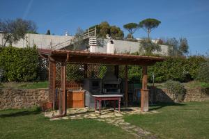 a barbecue grill in a garden with a roof at Linda's Retreat B&B in Fiano Romano