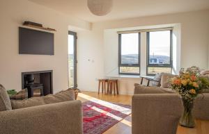 a living room with a fireplace and a tv at 3 Carbost in Tole