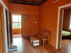 a room with two chairs and a table in it at Alloos homestay villa in Attappādi +3 photos